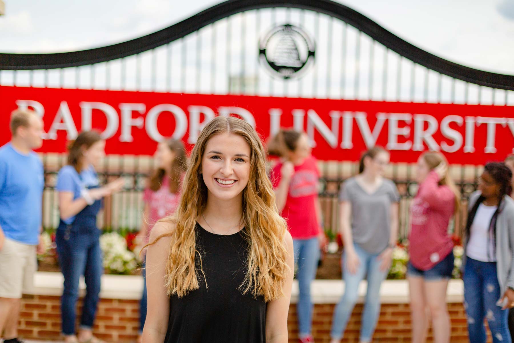 student with peers in front of Radford University entrance