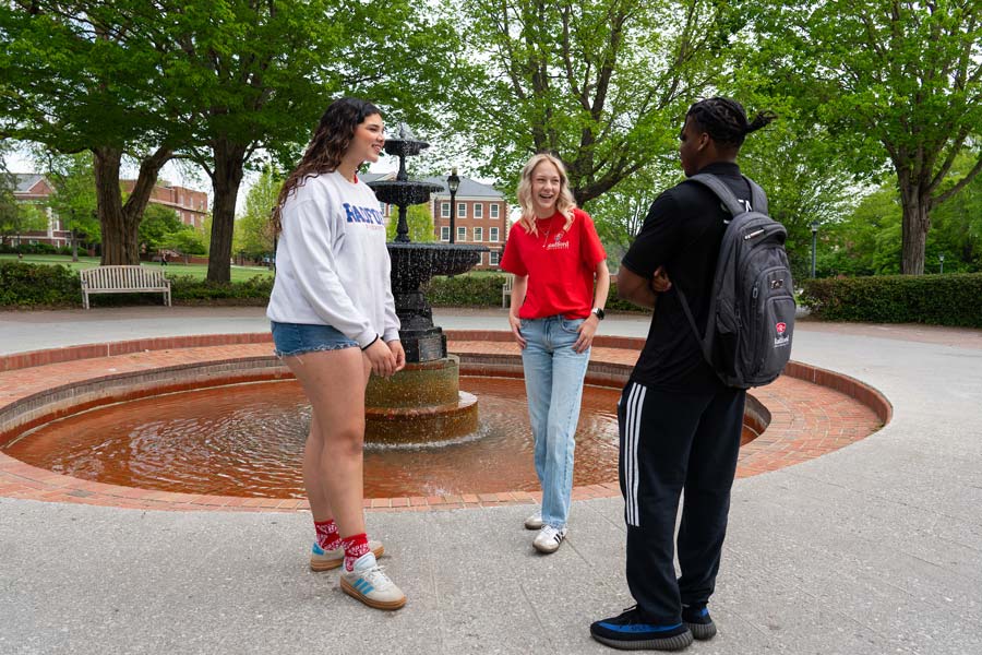 student stands in front of fountain