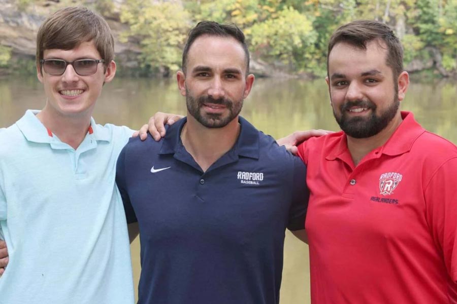 Radford's baseball coach and two students stand beside the New River.