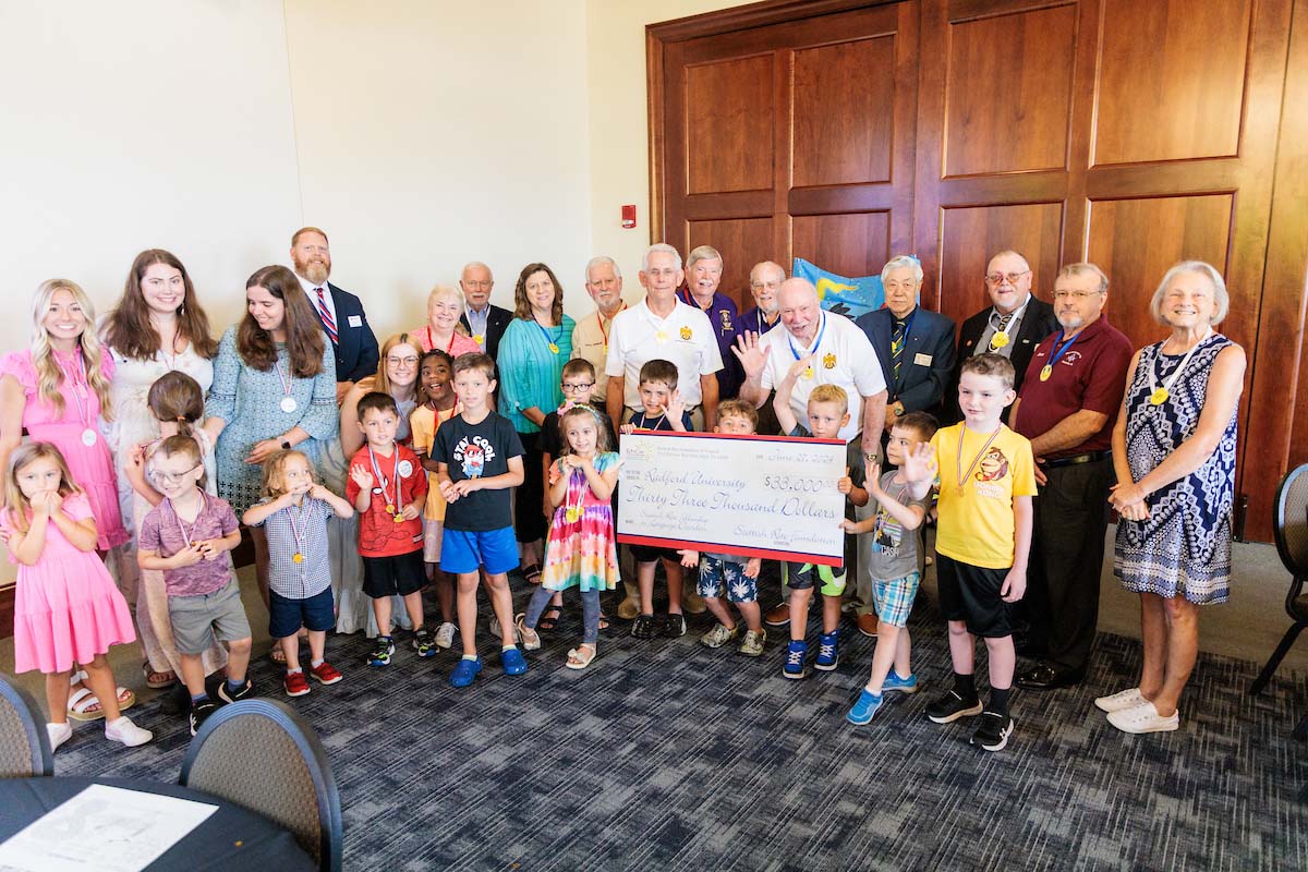 The students, supervisors and sponsors of the RiteCare Clinic summer day camp gather around a check that represents $33,000 donated this year by the Scottish Rite masons. 