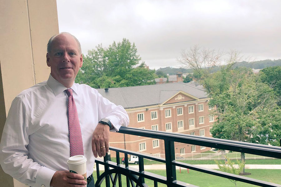 Alumni Michael Donnelly leans against a railing overlooking Radford University's campus.