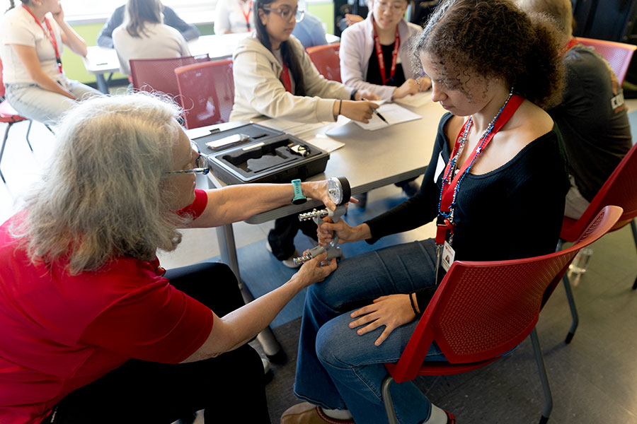 A Governor’s School student tests her grip strength with faculty from the Radford occupational therapy program.