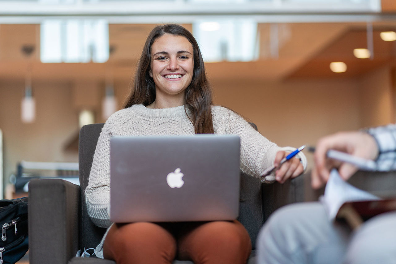 student smiling with laptop