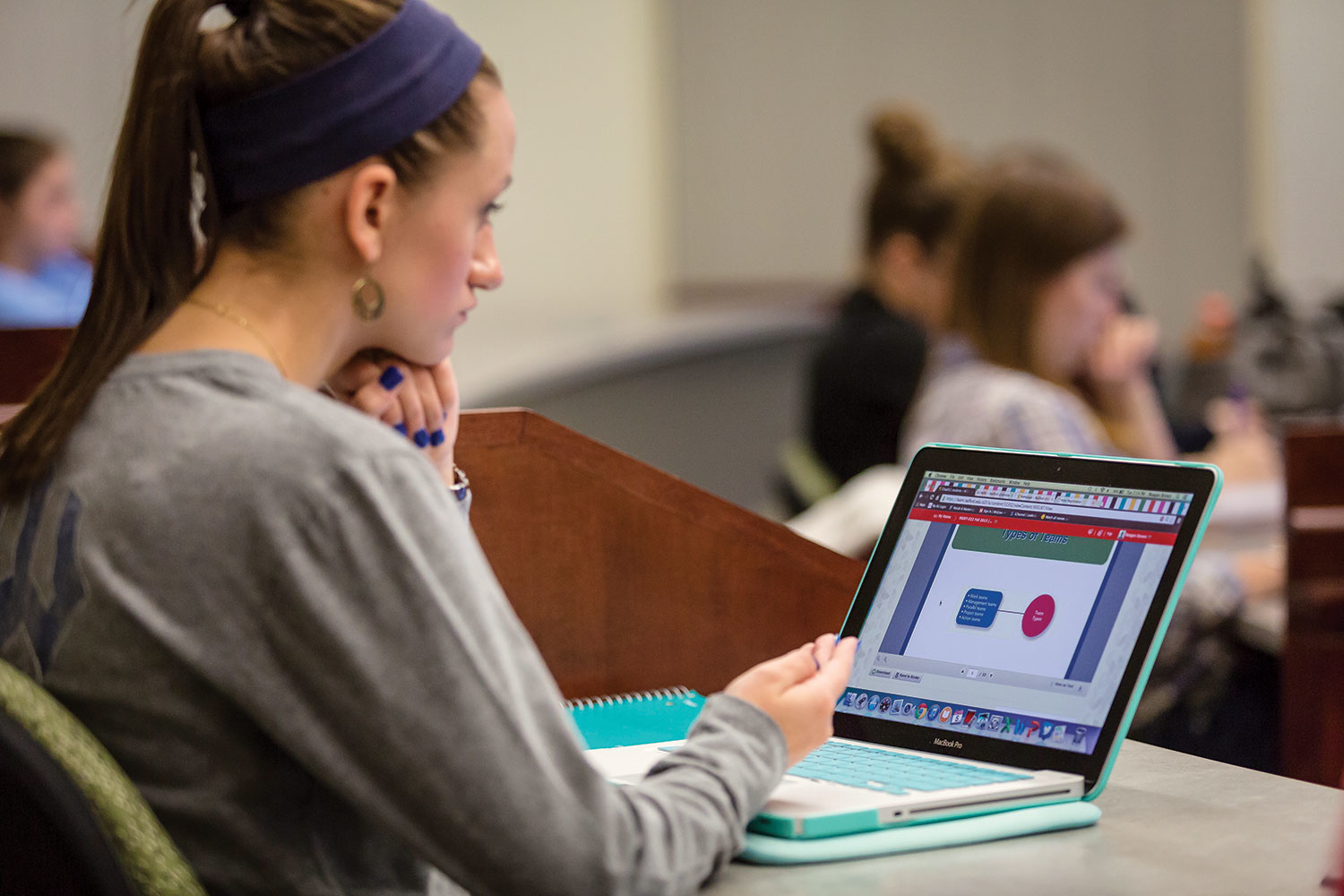 student sitting at a desk using a laptop