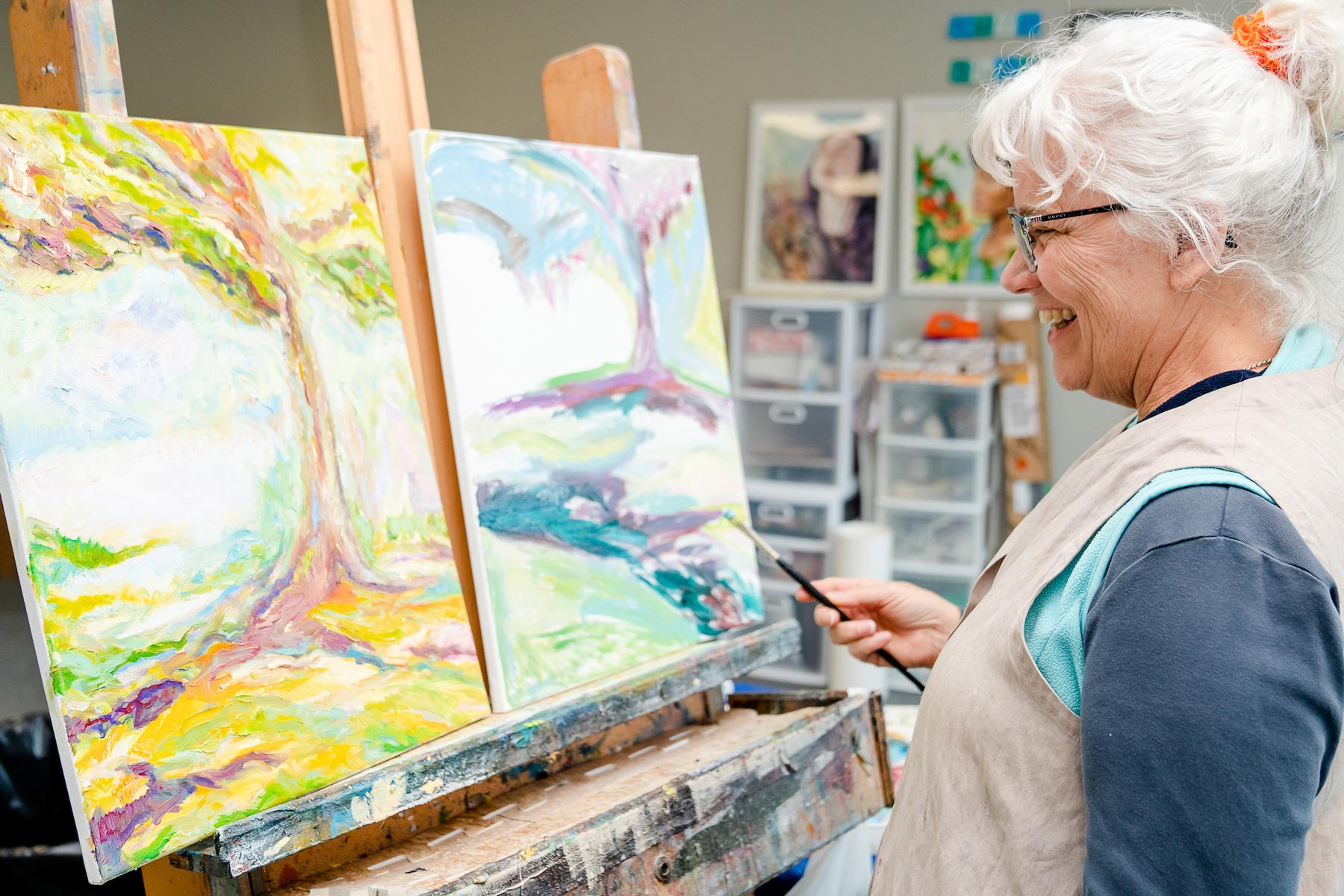 women in paint studio painting on canvas