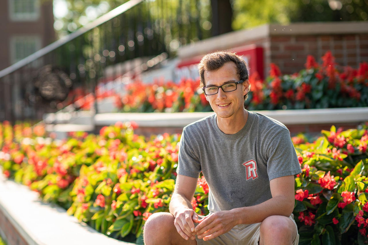 student sitting at the edge of a garden