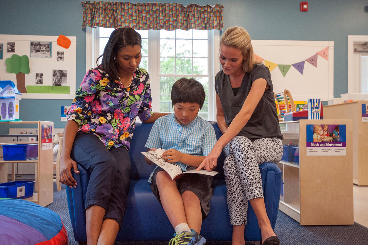 two teachers guiding a young student