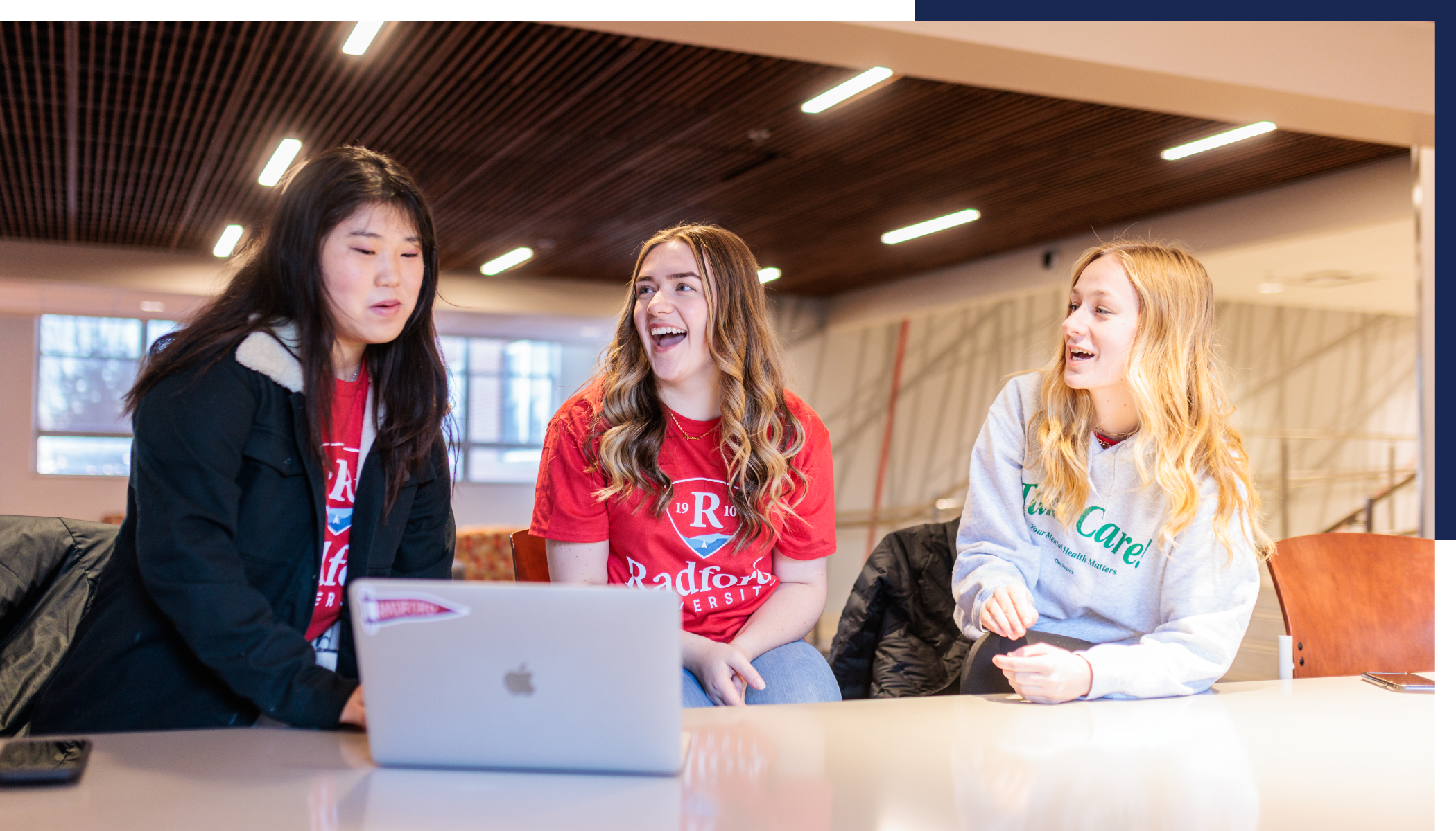 group of happy students looking at a computer