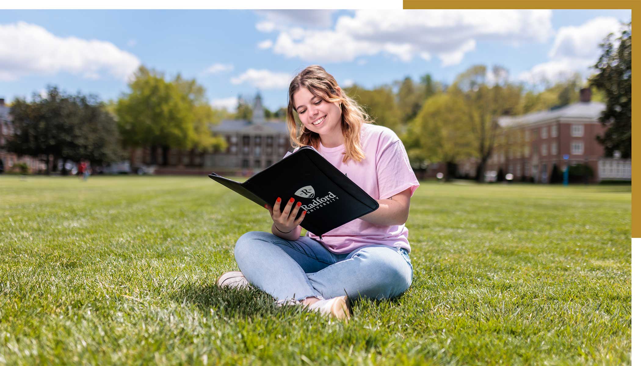 student reading through a notebook on campus