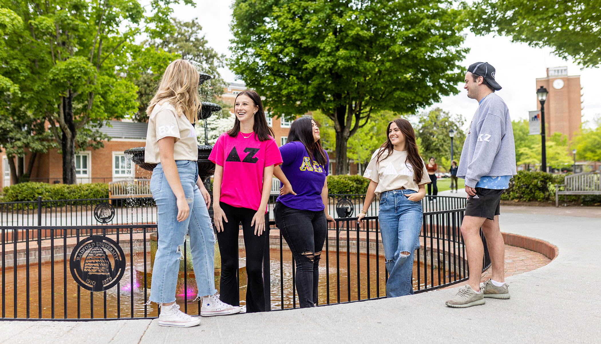Students involved in greek life standing around the fountain