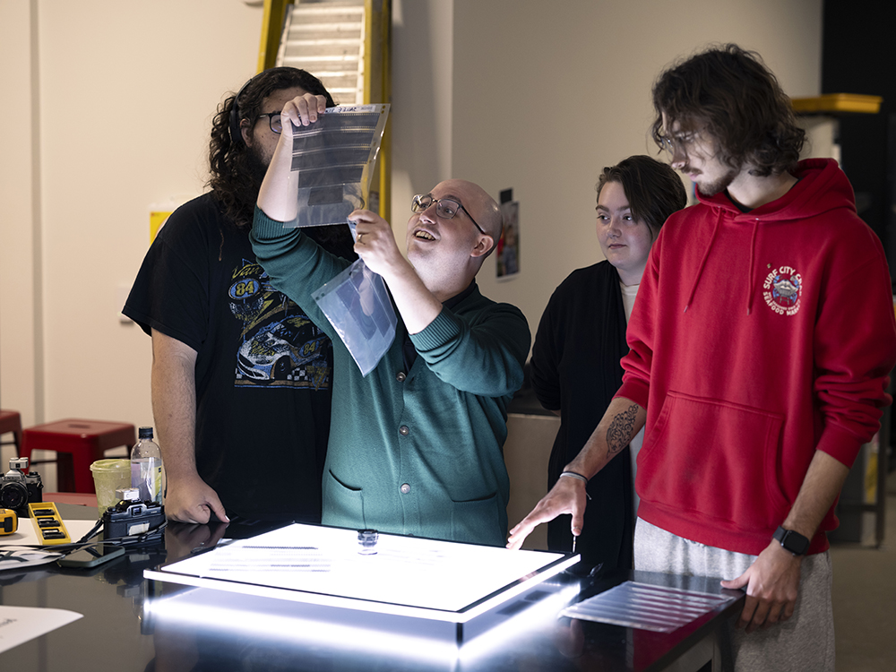 Sal Privitera working with photography students in a processing lab.