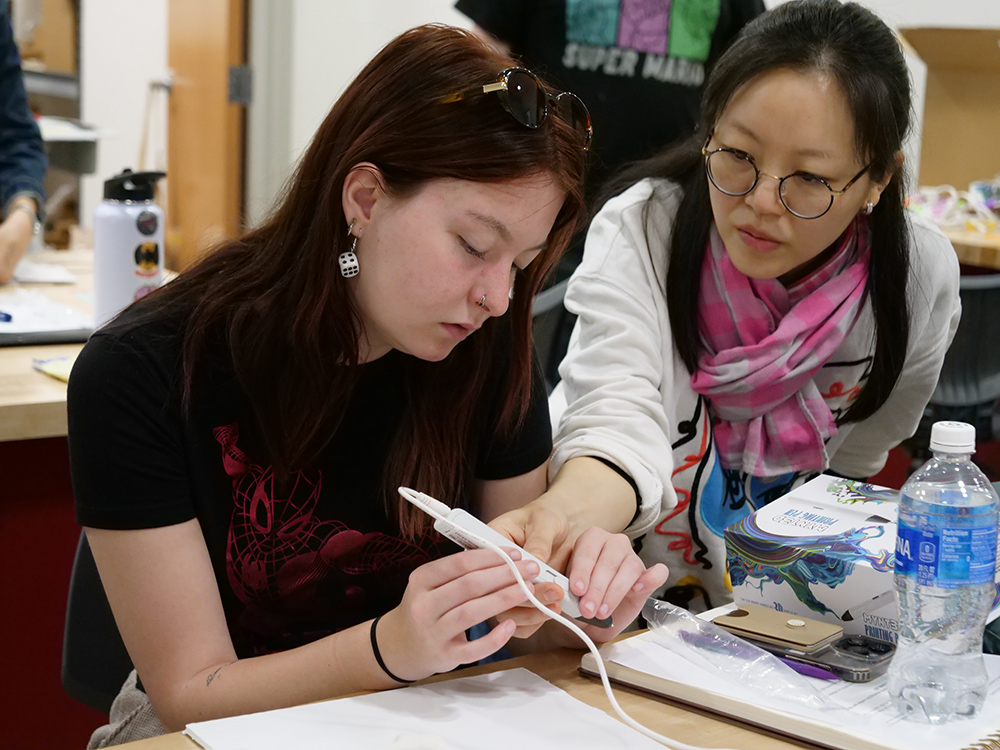 SungEun Park with student in Art Fundamentals class.