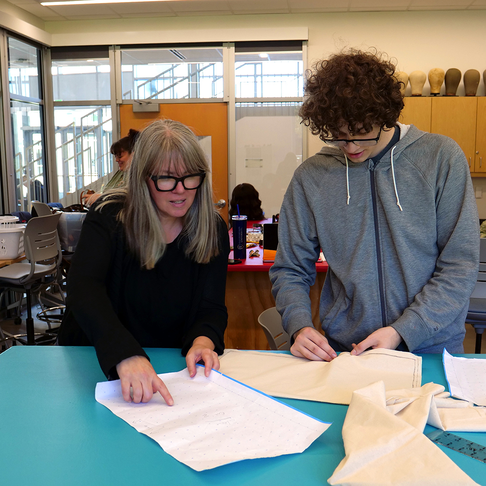 Jessica Gaffney works with student in the costume shop.