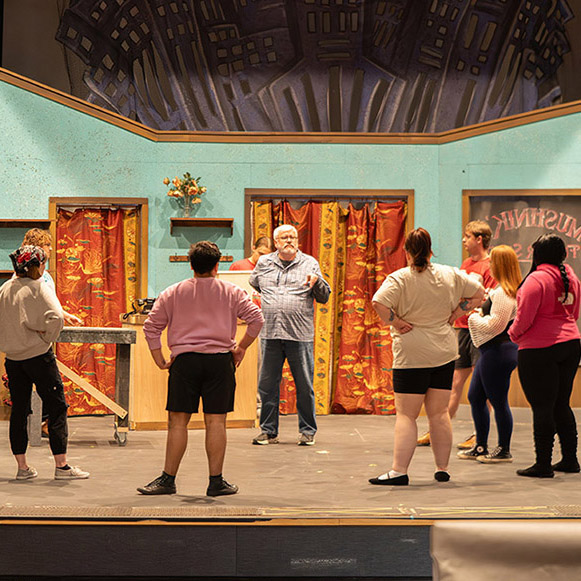 Director Wesley Young prepares actors for their rehearsal on the set of Little Shop of Horrors.