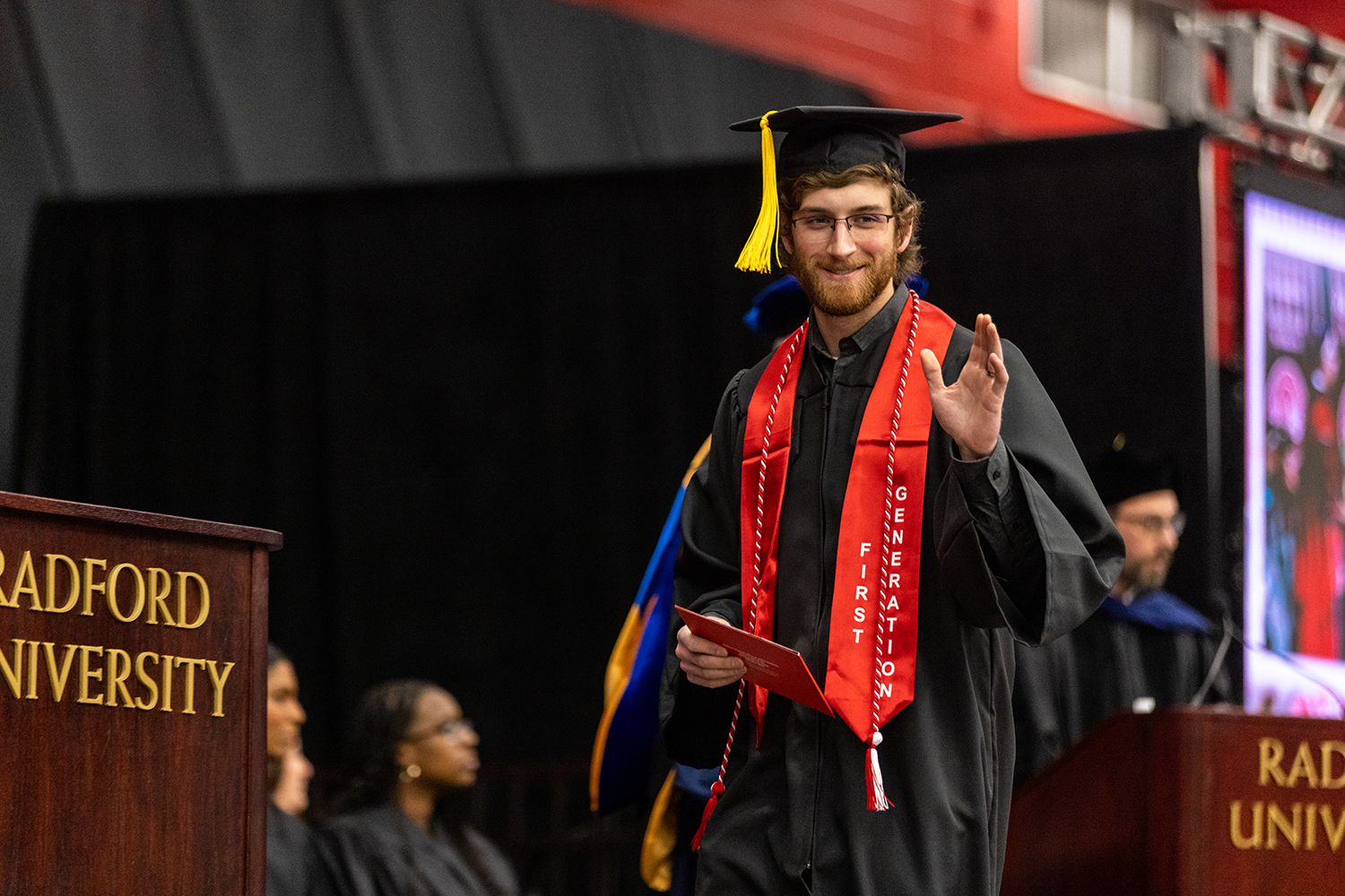 student walking across stage after receiving diploma